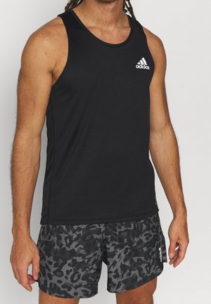 Canotta atletica nera senza maniche con scollatura rotonda e logo Adidas bianco; abbinata a pantaloni corti neri con motivo leopardato sottile.
