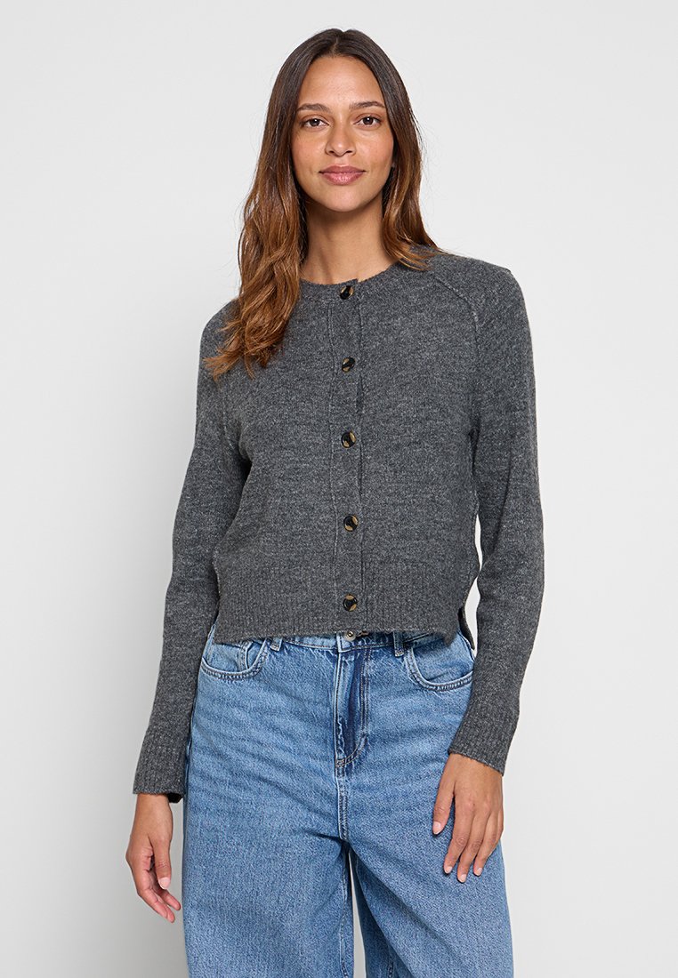 Grijze wollen cardigan met een ronde hals, voorzijde met knoopsluiting en lange mouwen. De textuur is zacht, met een iets verkorte pasvorm.