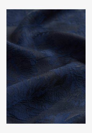 Granatowy materiał z delikatnym wzorem kwiatowym w splotach. Gładka tekstura z delikatnym połyskiem, układa się miękko. Bogaty, głęboki kolor.