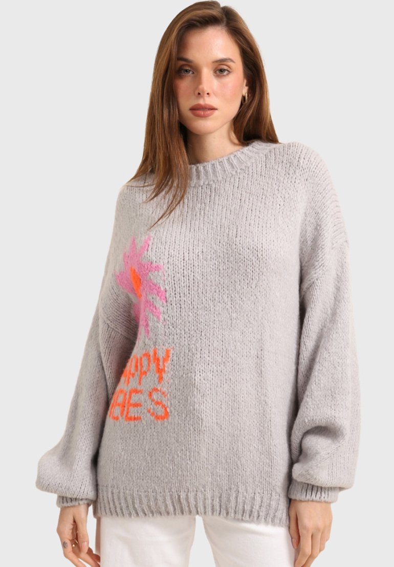 Pull en tricot gris clair avec des manches surdimensionnées ; présente un design floral coloré et un texte "abeilles heureuses" en rose et orange.