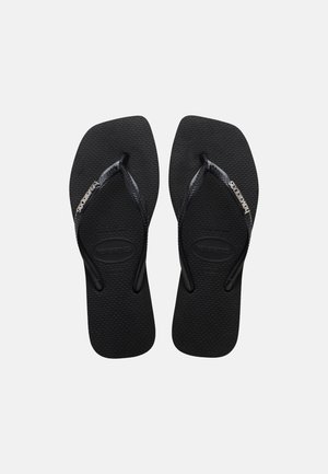 Black rubber flip-flops with textured soles and thin straps featuring the Havaianas logo in white on a plain background.