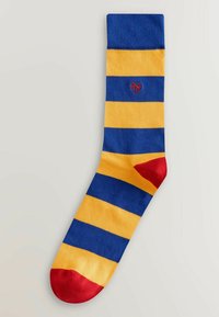 Chaussette avec de larges rayures horizontales bleues et jaunes, talon et pointe rouges, et un petit logo "NY" rouge brodé près du haut.