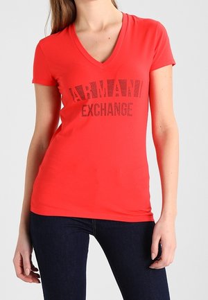 Rød v-hals t-shirt lavet af blød bomuldsblanding med trykt "ARMANI EXCHANGE"-logo i sort. Tætsiddende pasform med korte ærmer.