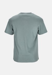 Kortärmad t-shirt i dämpad teal, tillverkad av mjukt bomullstyg, med rund halsringning och minimala sömnadsdetaljer vid fållen.
