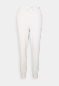 Wafelstructuur, crèmekleurige joggers met elastische tailleband, trekkoord en aansluitende boorden bij de enkel. Eenvoudig ontwerp en lichtgewicht materiaal.