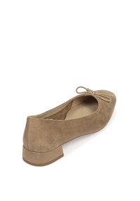 Bailarina de ante en color marrón claro con un pequeño tacón, que presenta una punta redondeada y un lazo en la parte delantera. Textura suave y diseño minimalista.