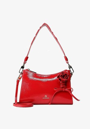 Bolso de mano de charol rojo con textura suave, con un adorno en forma de rosa, correa ajustable y cierre de cremallera. Logo de Aigner destacado claramente.