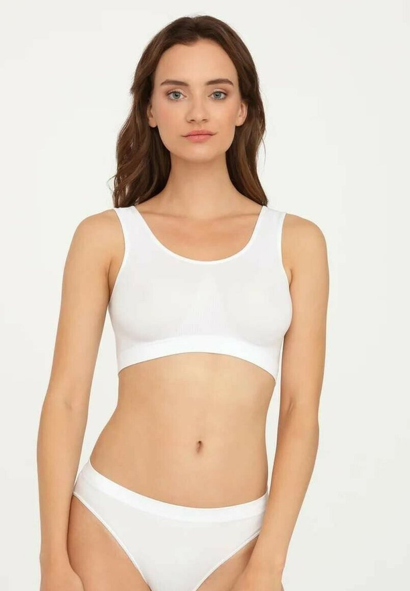 Biały bezszwowy stanik i pasujące majtki wykonane z miękkiej bawełny. Projekt charakteryzuje się dopasowanym krojem oraz szeroką, płaską gumką w talii.
