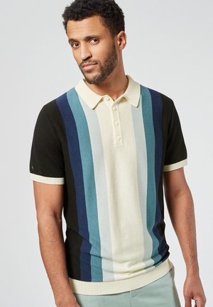 Polo à manches courtes en noir, crème et bleu rayé, avec un col classique, une patte de boutonnage et des accents côtelés sur les manches et l'ourlet.