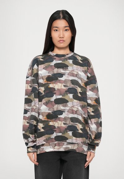 Sweatshirt à manches longues avec un motif abstrait multicolore comprenant des verts, des bruns et des noirs atténués. Texte "STIGLITZ" imprimé sur la poitrine.