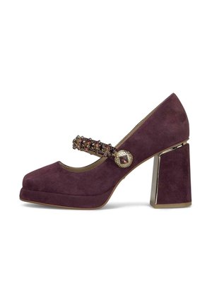 Zapato Mary Jane de ante morado con tacón ancho, correa con joyas y botón decorativo con acentos dorados en el lateral.
