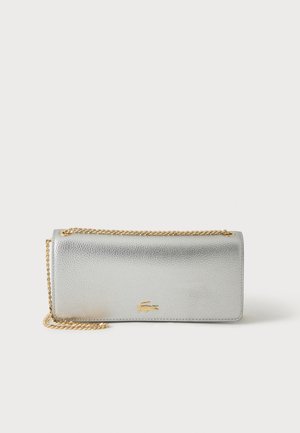 Sac pochette en cuir texturé argent avec une bandoulière chaîne dorée et un petit logo crocodile doré au centre avant.