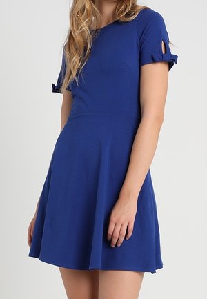 Niebieska sukienka z krótkim rękawem, dopasowanym gorsetem i rozkloszowaną spódnicą, z pętlami na rękawach oraz gładką, elastyczną tkaniną.