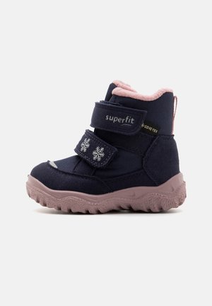 Botas de inverno azul-marinho com detalhes em rosa, apresentando duas tiras de Velcro, desenhos de flocos de neve, solas texturizadas e um forro de fleece suave.