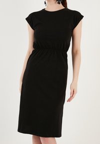 Czarna sukienka z krótkimi rękawami, elastyczną talią i długością do kolan. Wykonana z gładkiego materiału, cechująca się prostym, dopasowanym krojem.