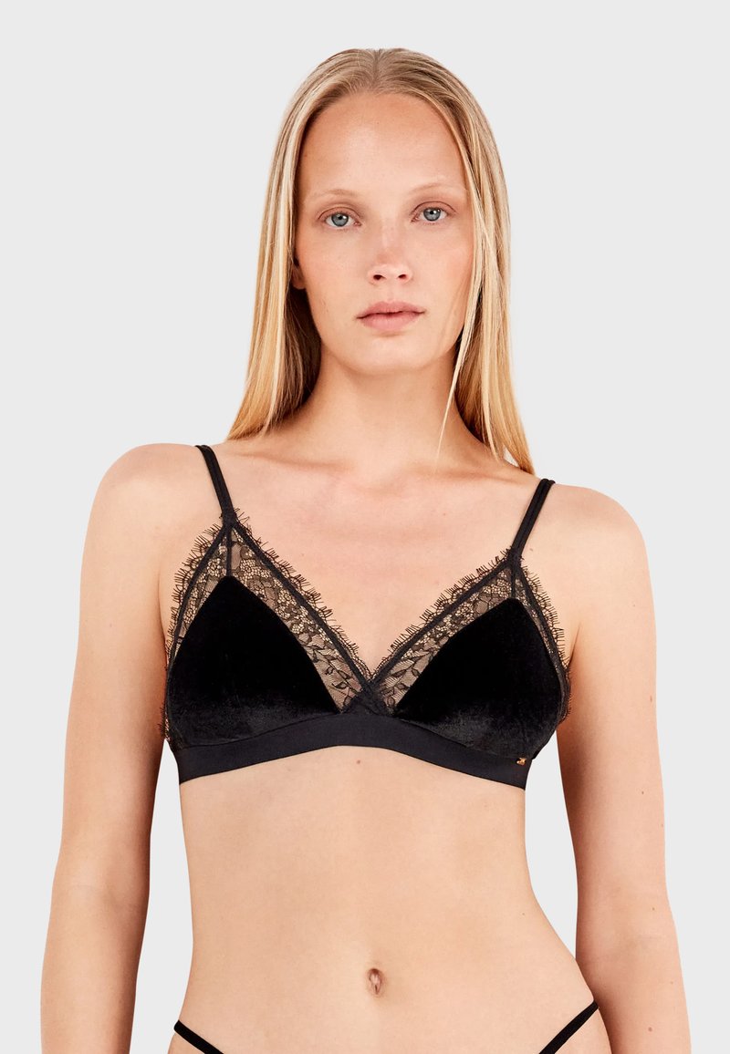 Crni baršunasti bralette s čipkastim rubom, trokutastim čašicama, podesivim trakama i glatkom teksturom. Ima minimalistički dizajn bez jastučića.
