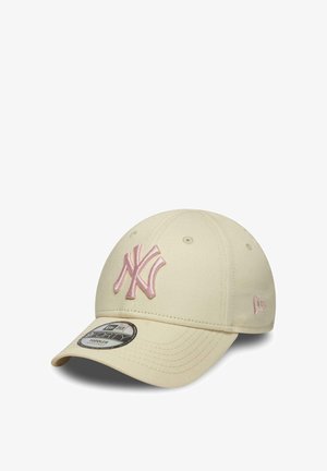 Cream-colored baseball cap with a curved brim, featuring a pink embroidered New York Yankees logo on the front and a side logo emblem.