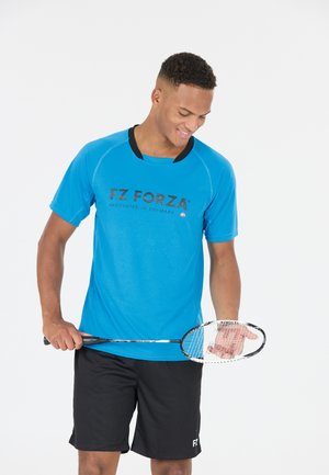 Blå atletisk t-shirt med korte ærmer og sorte accenter, med logoen "FZ FORZA" på forsiden. Sorte shorts og et badmintonbat.