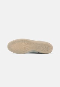 Εξωτερική σόλα αθλητικού παπουτσιού με ανάγλυφη μπεζ γκρίζα επιφάνεια και ομόκεντρους κύκλους, με ένδειξη μεγέθους 37 και το εμπορικό σήμα 'VIGARD'.