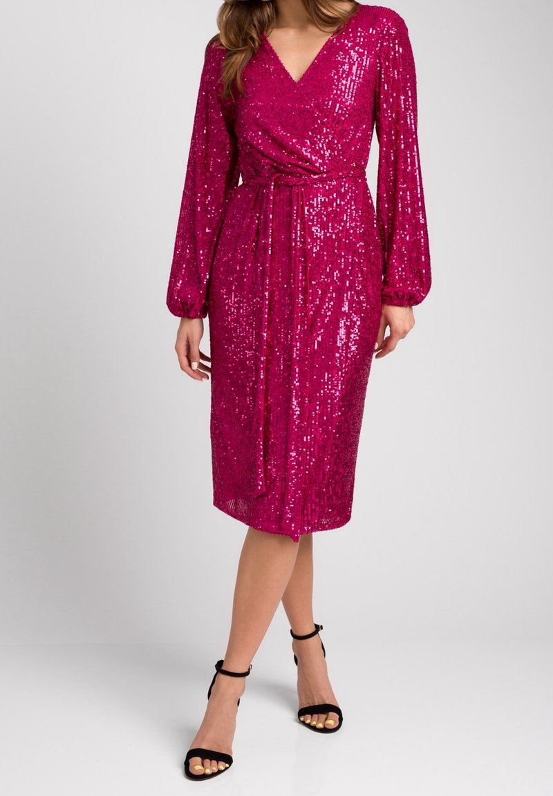 Robe en sequins fuchsia avec un design enveloppant, décolleté en V profond, manches bouffantes longues et ceinture à la taille. Longueur sous le genou avec une texture de tissu lisse.