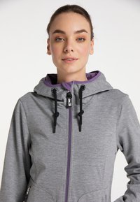 Felpa grigia con zip, foderata in viola, dotata di cappuccio con coulisse, zip frontale e tasche laterali. Texture liscia e vestibilità slim.
