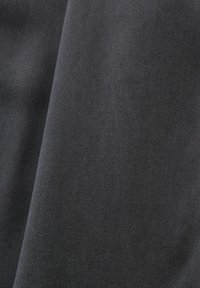 Tissu gris foncé avec une texture de tissage en diagonale fine, plié doucement.