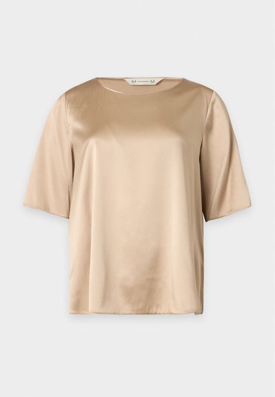 Blouse en satin beige à manches courtes, encolure ronde, texture lisse et coupe ample, présentée sur un fond uni.