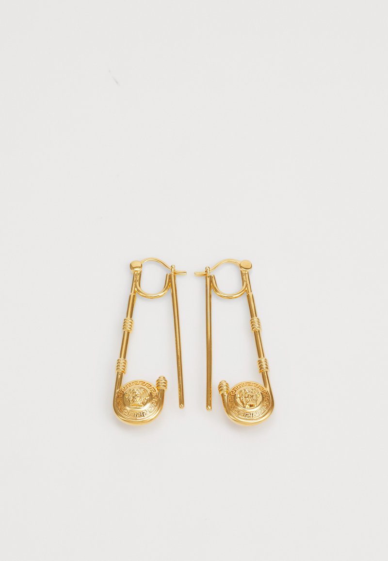 Brincos de ouro desenhados como alfinetes de segurança, com medalhões circulares que apresentam detalhes intrincados e acentos texturizados. Design elegante e moderno.