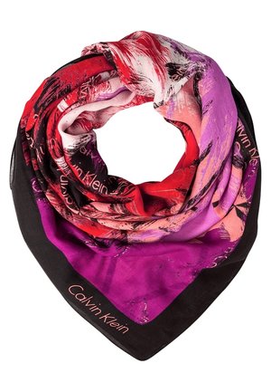 Jedwabny szalik z abstrakcyjnymi czerwonymi, różowymi, purpurowymi i czarnymi wzorami, złożony w pętlę, z tekstem "Calvin Klein" na czarnym brzegu.