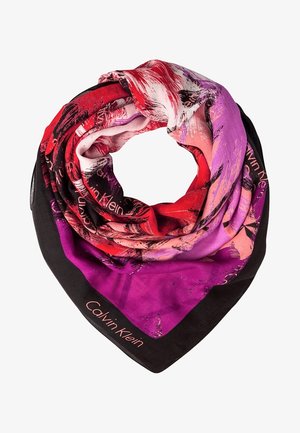 Foulard en soie avec des motifs abstraits rouges, roses, violets et noirs, plié en boucle, avec le texte "Calvin Klein" sur la bordure noire.
