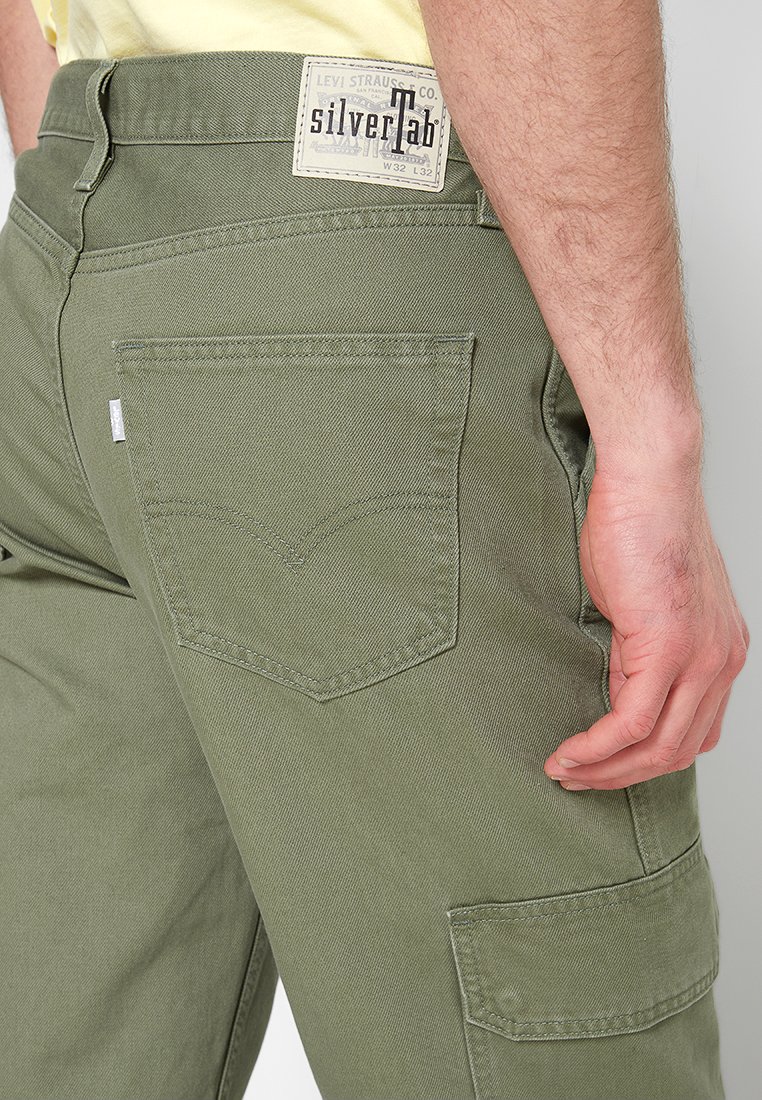 Pantalons cargo verts olive au coupe droite, dotés de grandes poches latérales et d'une poche arrière avec une couture incurvée et une étiquette portant la mention "Silver Tab".