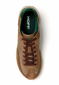 Sneaker in suede marrone con superficie texturizzata, lacci marroni scuri, dettagli verdi e soletta con logo. Punta arrotondata e collare imbottito.