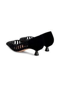 Tacones negros con parte superior trenzada, punta afilada y pequeños tacones en forma de cono brillantes. Hechos de materiales texturizados con un diseño recortado.