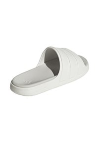 Chanclas blancas de deslizamiento con una textura suave, que presentan tres franjas horizontales. Fabricadas con material de espuma y con una suela acolchada.