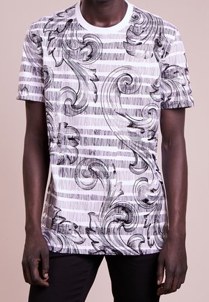 Czarna i biała koszulka z krótkim rękawem, ozdobiona wirującymi wzorami kwiatowymi na tle poziomych pasków. Wykonana z lekkiego materiału, z okrągłym dekoltem.