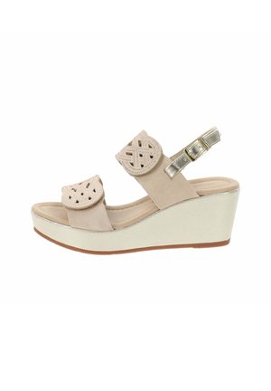 Sandali wedge beige con doppie cinghie testurizzate, modelli intagliati intricati, un fibbia di metallo e una suola in gomma antiscivolo.