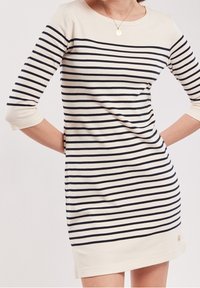 Randig klänning med trekvartslånga ärmar, marinblå och krämfärgad, mjukt bomullsmaterial, rundad halsringning och logotypdetalj vid fållen.