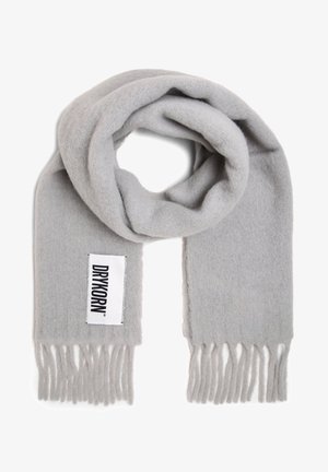 Écharpe en laine grise avec une texture douce, des extrémités à franges et une étiquette blanche sur laquelle est imprimé "DRYKORN" en noir. Le design est simple et dépouillé.