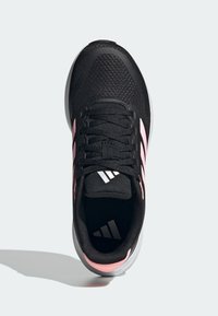 Czarne buty sportowe z siateczkowym wierzchem, różowymi akcentami, teksturowanymi sznurowadłami i wyściełanym kołnierzem. Na języku znajdują się trzy białe paski w logo.