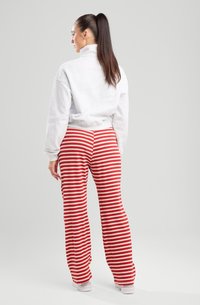 Gray fleece sweatshirt with a high collar, paired with red and cream striped ribbed pants, featuring a relaxed fit and soft texture.