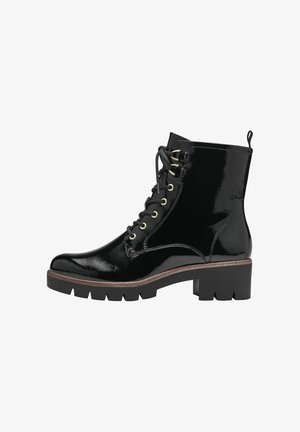 Black patent leather ankle boots featuring a rounded toe, lace-up design with gold-tone hardware, thick textured sole, and rear pull tab.