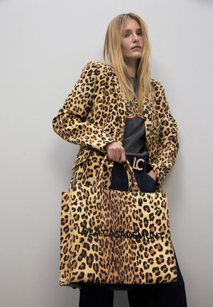 Bolso tote con estampado de leopardo y asas cortas, hecho de tela texturizada, con un llamativo logotipo de la marca en negro. Combinado con una chaqueta a juego.