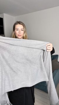 Hall grey kudumiga sule, pehme tekstuuri ja teksitud äärtega, hoitud käte sirutamisel, et näidata selle ristküliku kuju ja langevust.