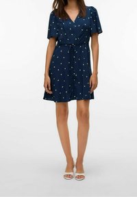 Robe boutonnée bleu marine à manches courtes, avec une taille nouée et de petits motifs verts. Tissu lisse avec une coupe décontractée.