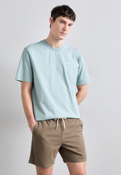 Lichtblauw katoenen t-shirt met korte mouwen en een ronde hals, gecombineerd met tan shorts met een elastische tailleband en een trekkoord.