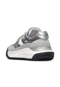 Baskets de sport grises avec des accents en daim et métalliques. Présentent un swoosh blanc, une tige grise texturée et une épaisse semelle en caoutchouc noire.