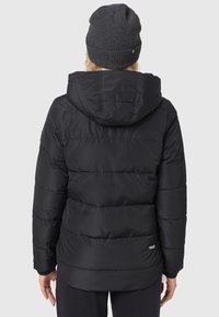 Sort pufferjakke med hætte, med et quiltet design og elastiske manchetter. Bruges med en mørkegrå strikket hue. Ensfarvet baggrund.