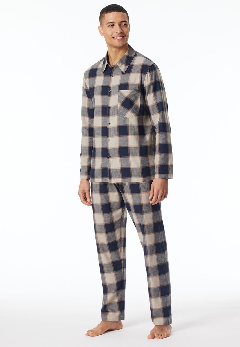 Set di pigiama in flanella a quadri nei colori blu navy, beige e grigio. La camicia presenta bottoni e una tasca sul petto, mentre i pantaloni hanno una vita elasticizzata.