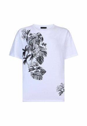 T-shirt bianca a maniche corte con stampa botanica nera che presenta grandi foglie e fiori sul lato sinistro e nell'angolo in basso a destra.