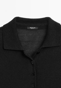 Black knitted button-up polo shirt with collar, showing upper front and brand label "Massimo Dutti Made in Italy."
